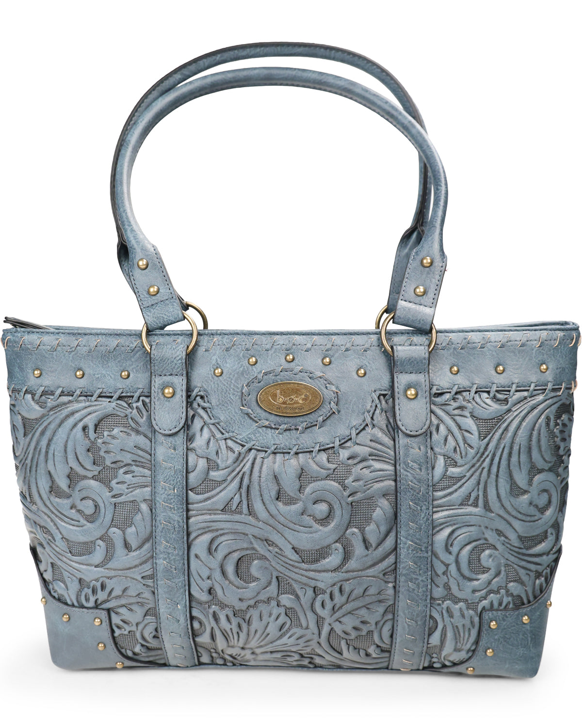 A blue tooled leather handbag with intricate scrollwork embossing, gold-tone studs, and double top handles, shown against a plain white background.