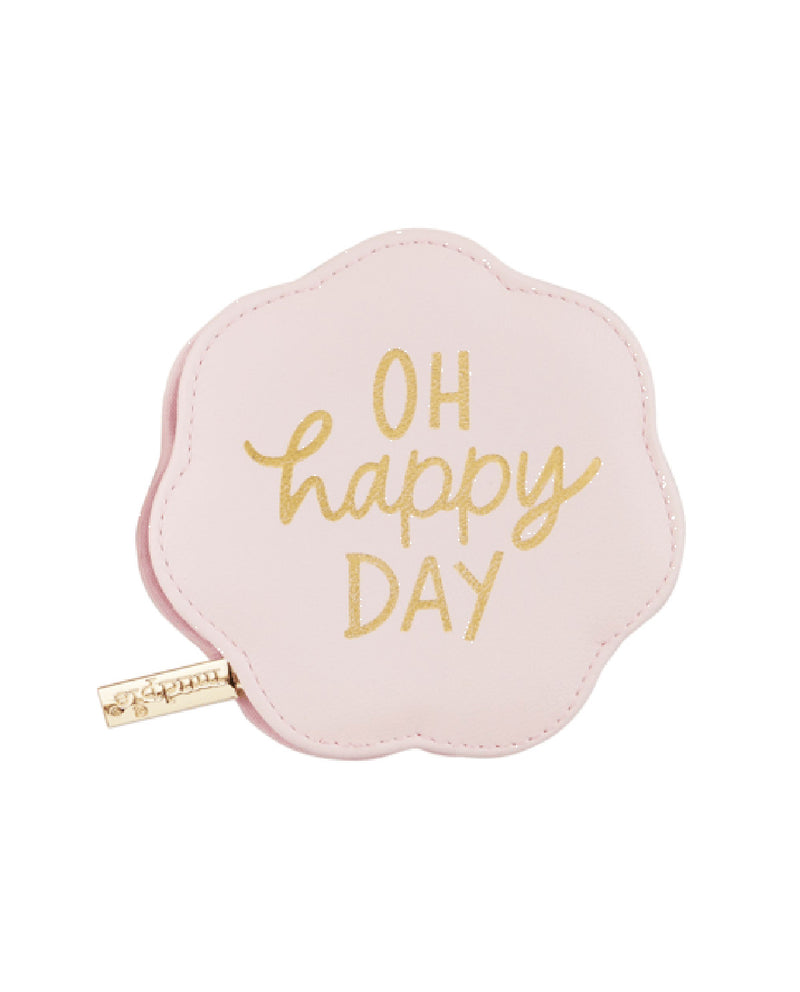 A small, scalloped-edge coin purse in light pink faux leather with 'OH happy DAY' printed in gold foil lettering, featuring a gold zipper pull with the brand name 'Sapna'.