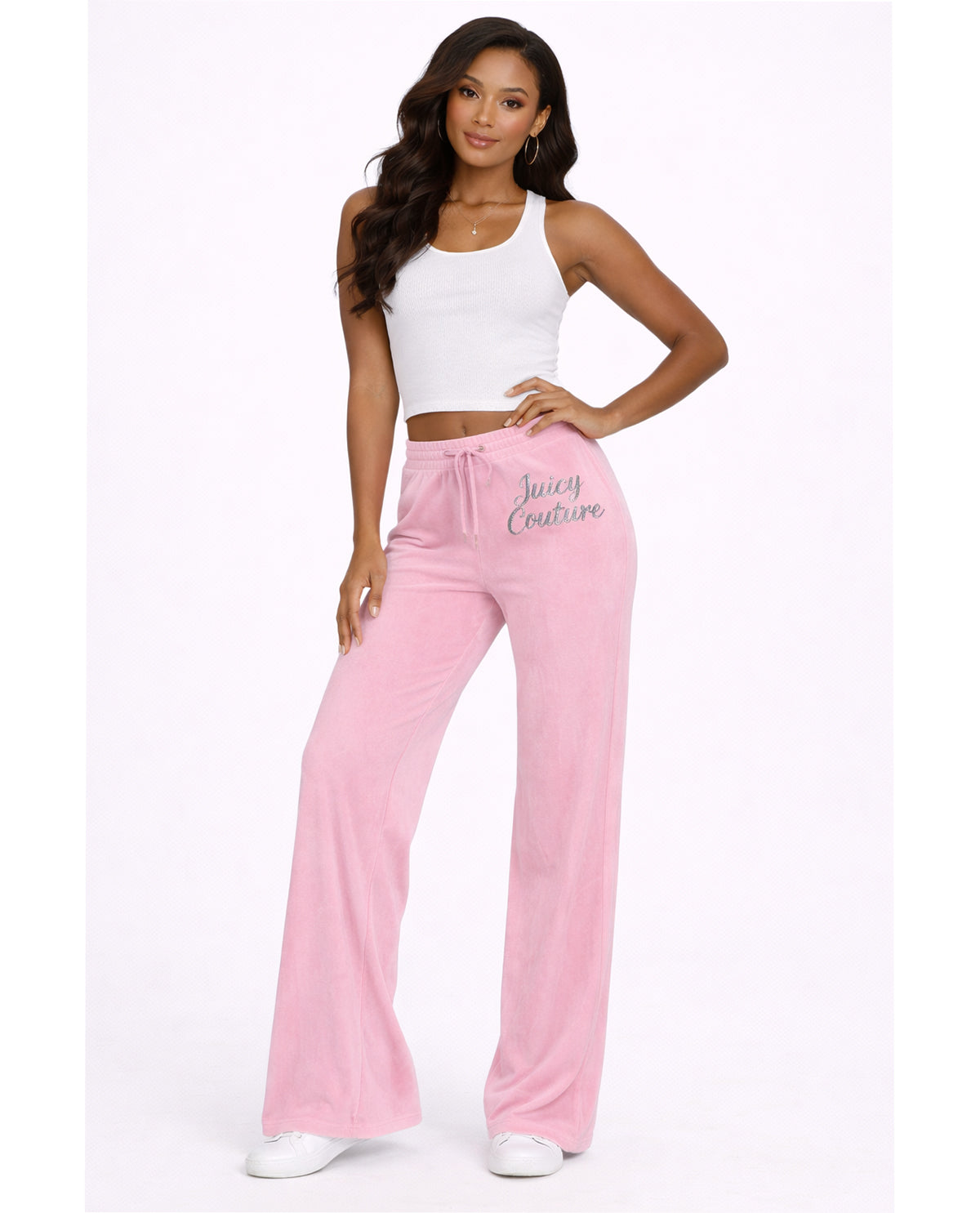 Woman wearing pink pants with 'Juicy Couture' branding on a white background