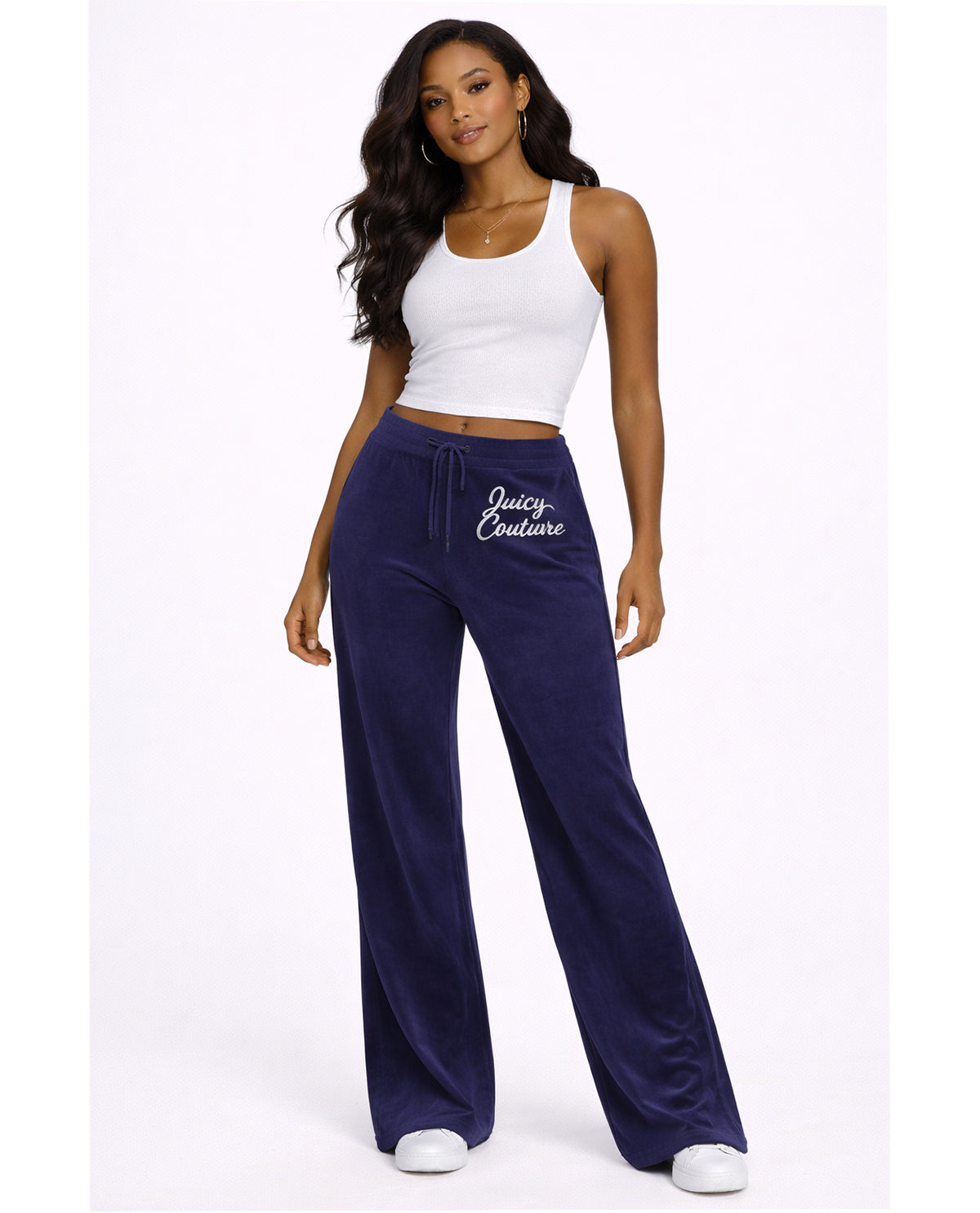Woman wearing navy 'Juicy Couture' sweatpants and white top on a white background