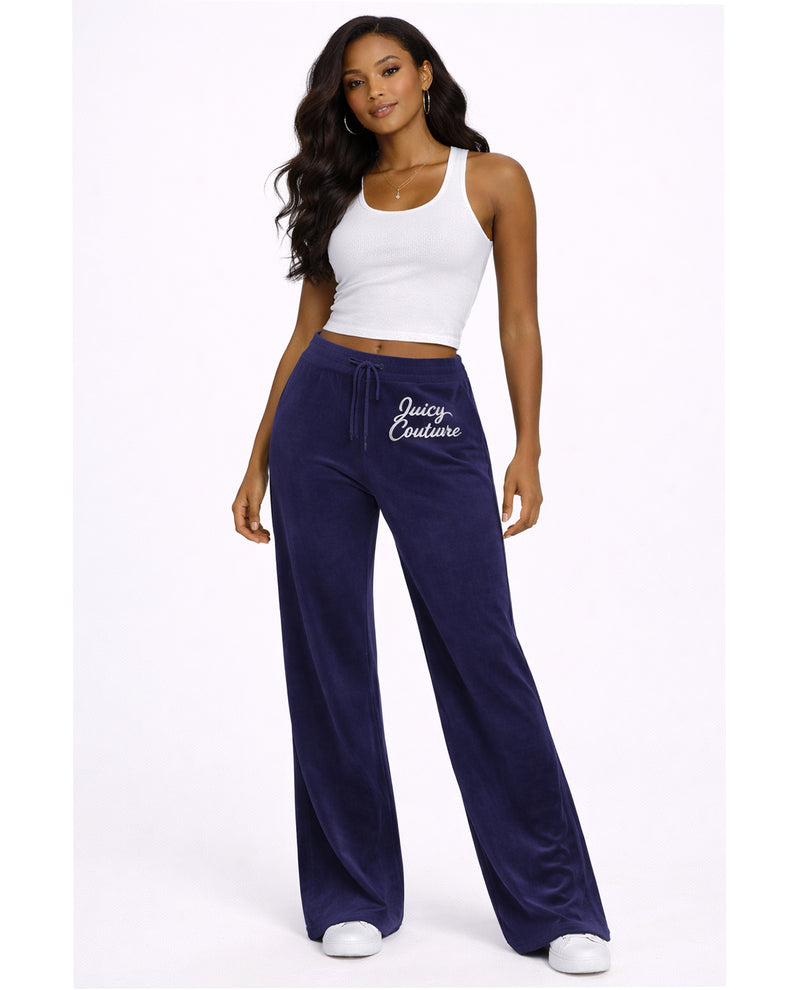 Woman wearing navy 'Juicy Couture' sweatpants and white top on a white background