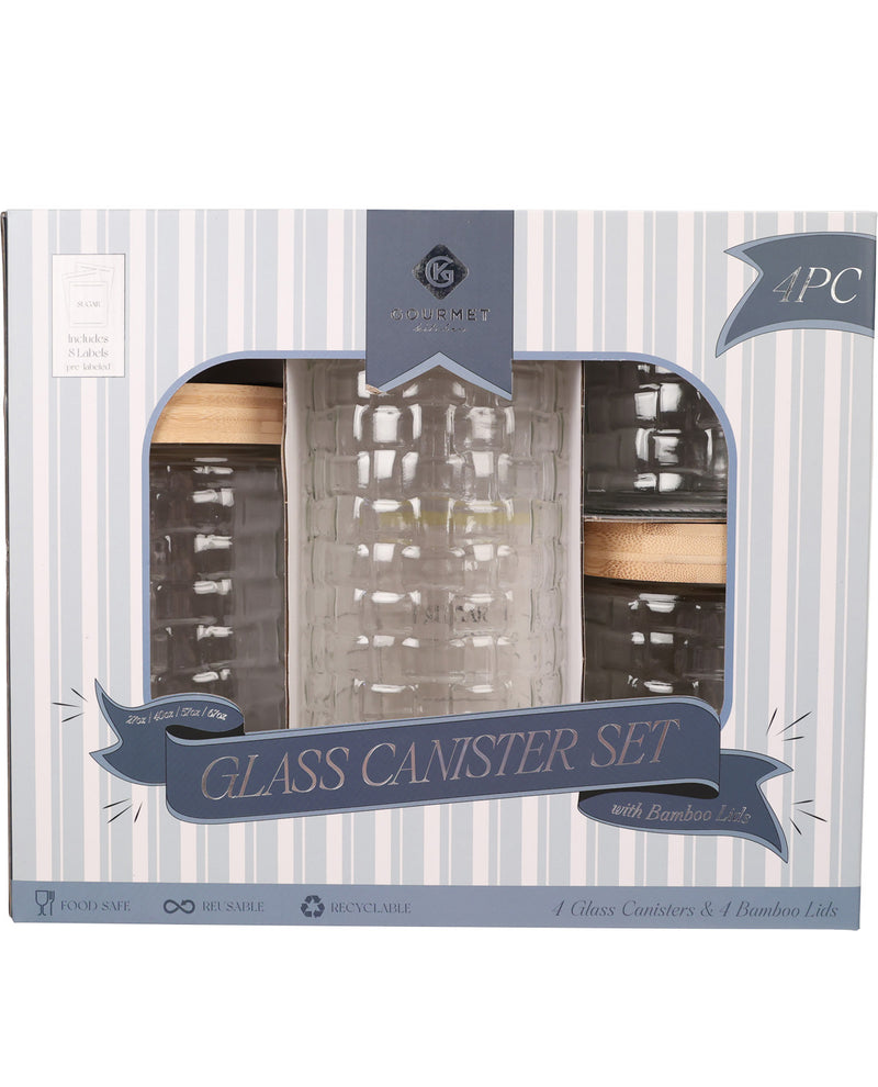 A 4-piece glass canister set in its retail packaging, featuring a striped box with a clear window showing two textured clear glass canisters and two dark glass canisters with light wood lids.