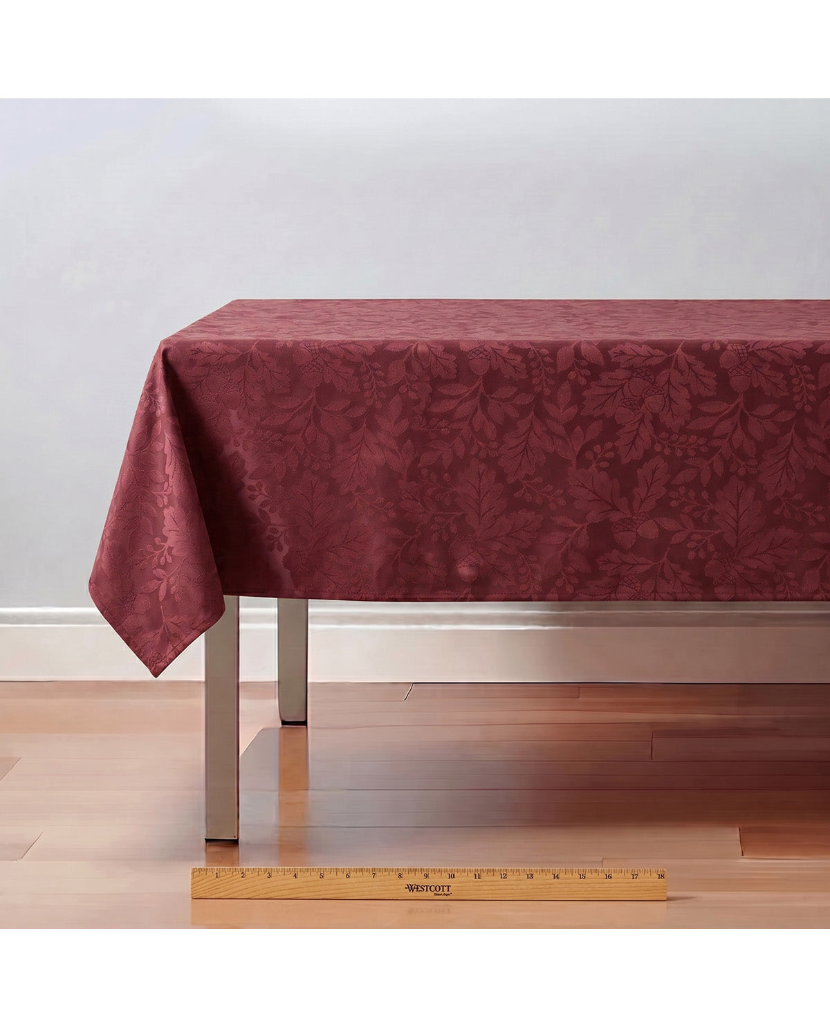 Red tablecloth on a wooden table with a ruler for scale against a white wall.