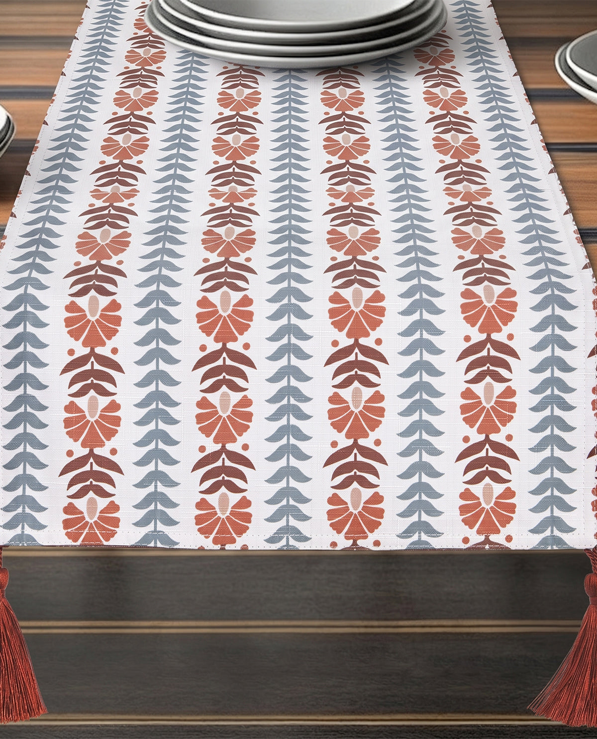 Decorative table runner with leaf pattern on a wooden table