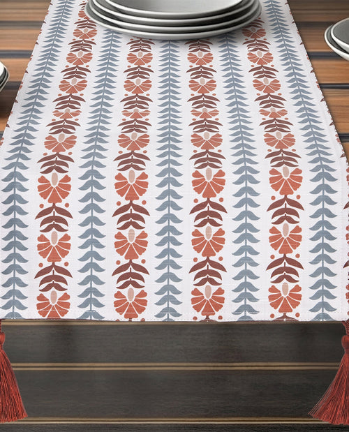 Decorative table runner with leaf pattern on a wooden table