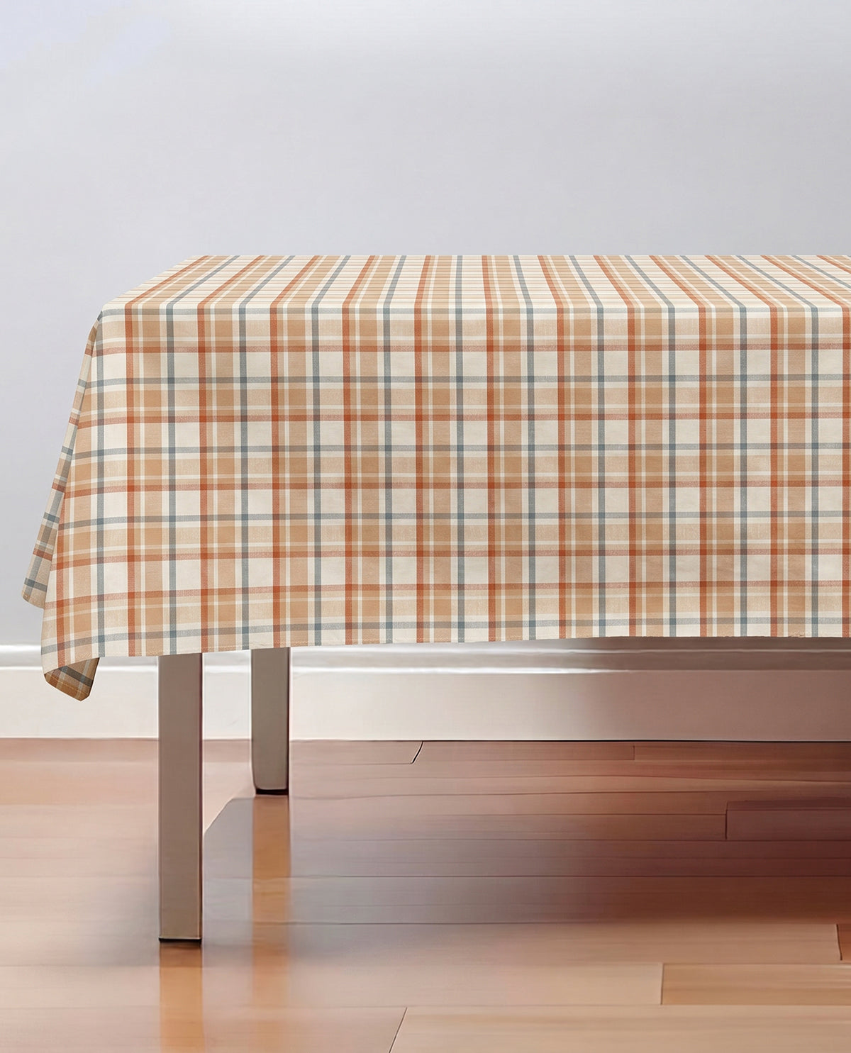 Table with a plaid tablecloth on a wooden floor and white wall background