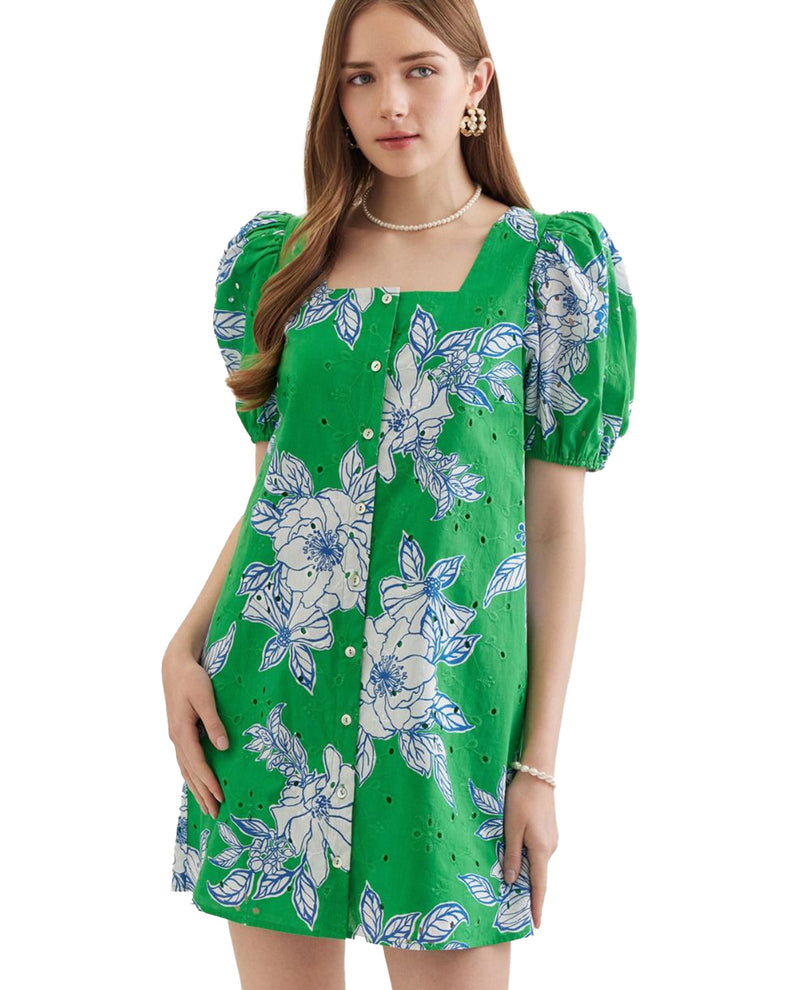 Woman wearing a green floral dress on a white background