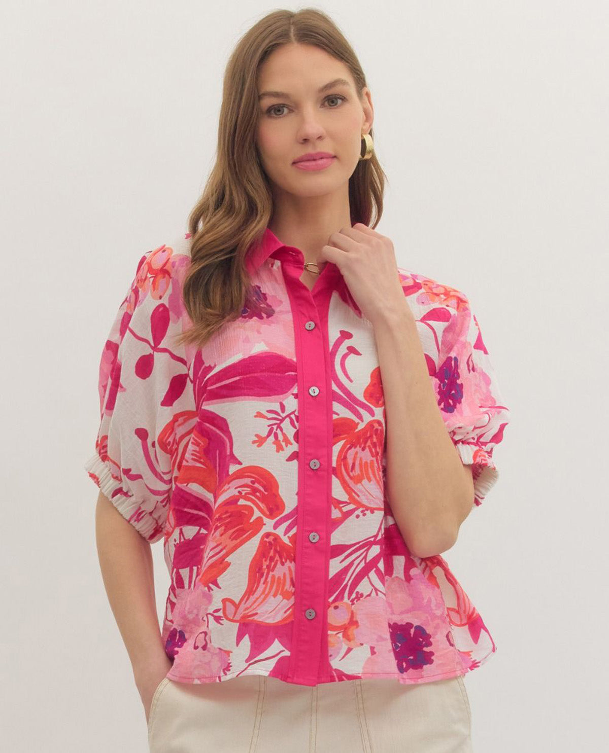 Woman wearing a pink floral blouse against a white background