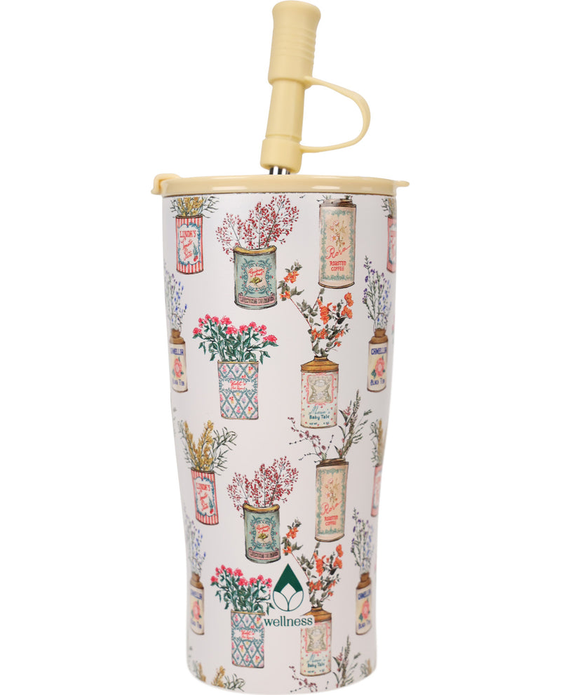 A tall insulated tumbler with a cream-colored straw and matching lid, decorated with a vintage-style pattern of illustrated flower vases on a light pink background. The brand name 'wellness' is printed near the bottom.