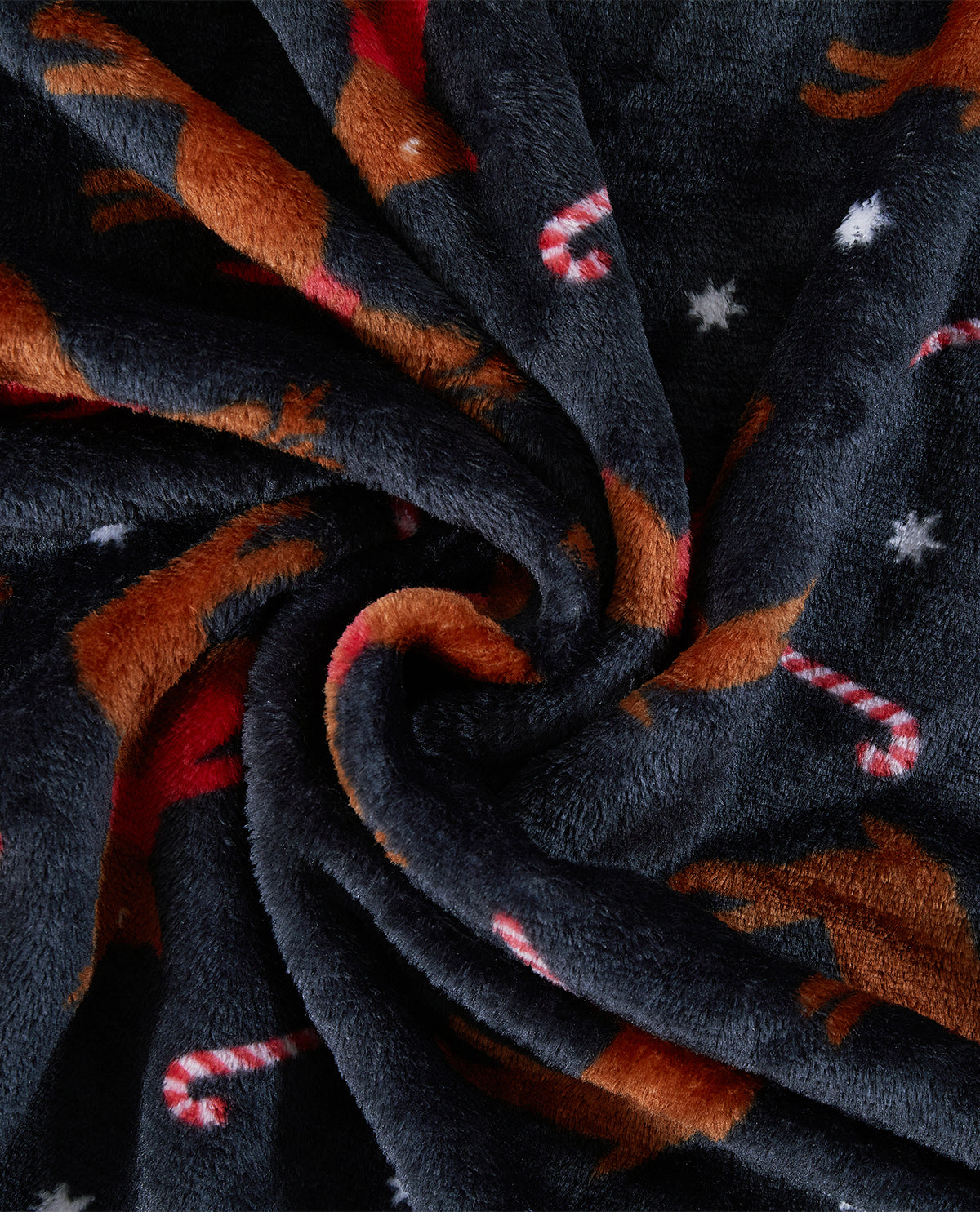 A close-up of a plush fleece blanket with a holiday dachshund print, featuring brown dachshunds, red and white candy canes, and white stars on a dark charcoal background.