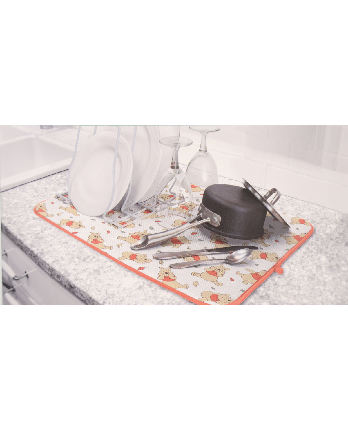 Dish drying rack with dishes and utensils on a kitchen counter