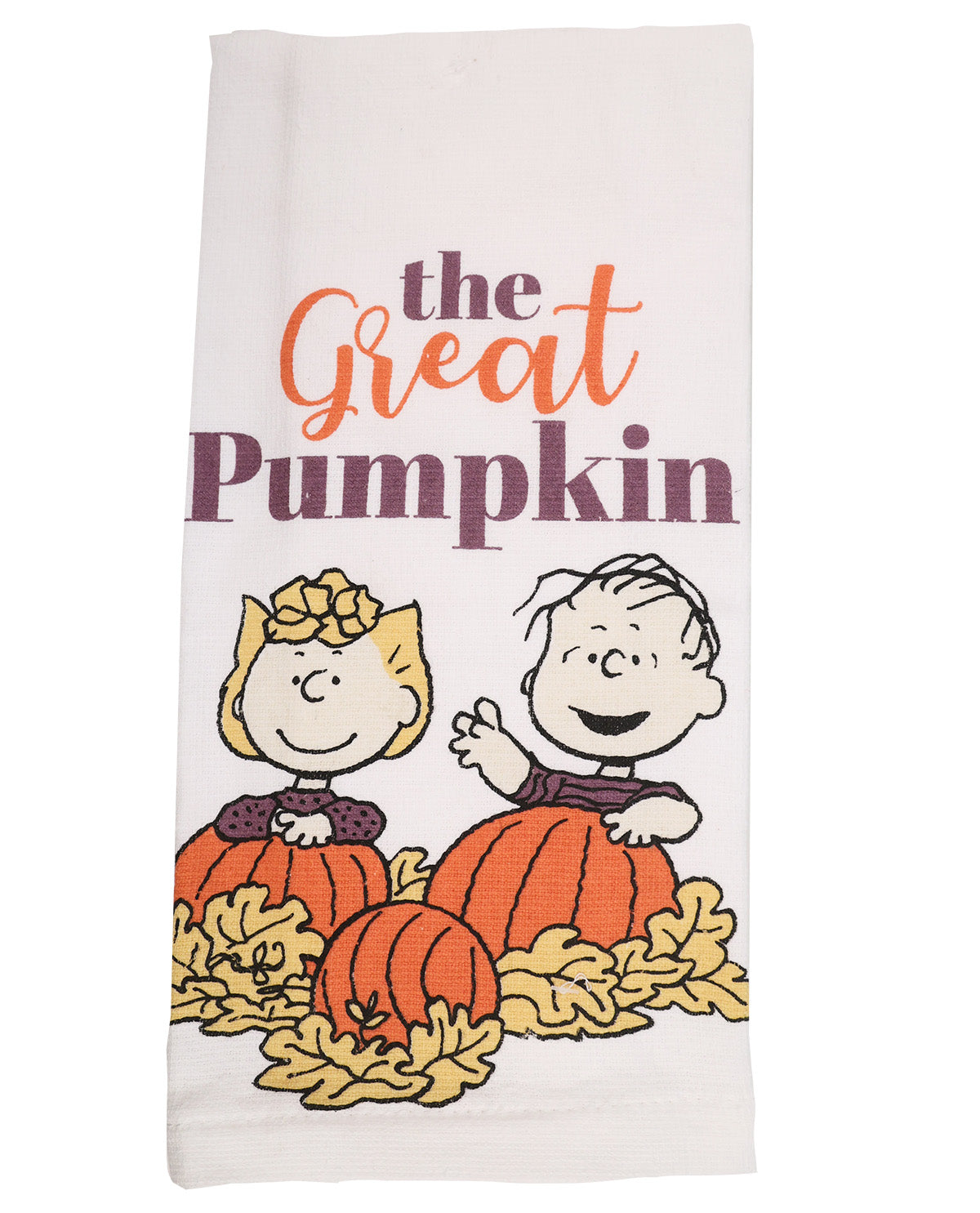 A white kitchen towel featuring a Peanuts autumn graphic with the text 'the Great Pumpkin' and Charlie Brown and Snoopy sitting in pumpkins among yellow leaves.