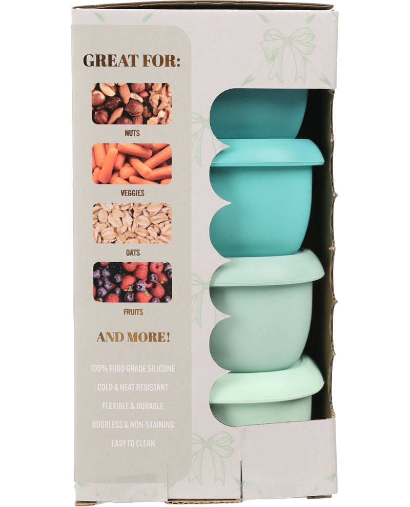 A boxed set of four silicone baby feeding bowls in pastel mint green and aqua blue, shown in its retail packaging with a window and food-use graphics.