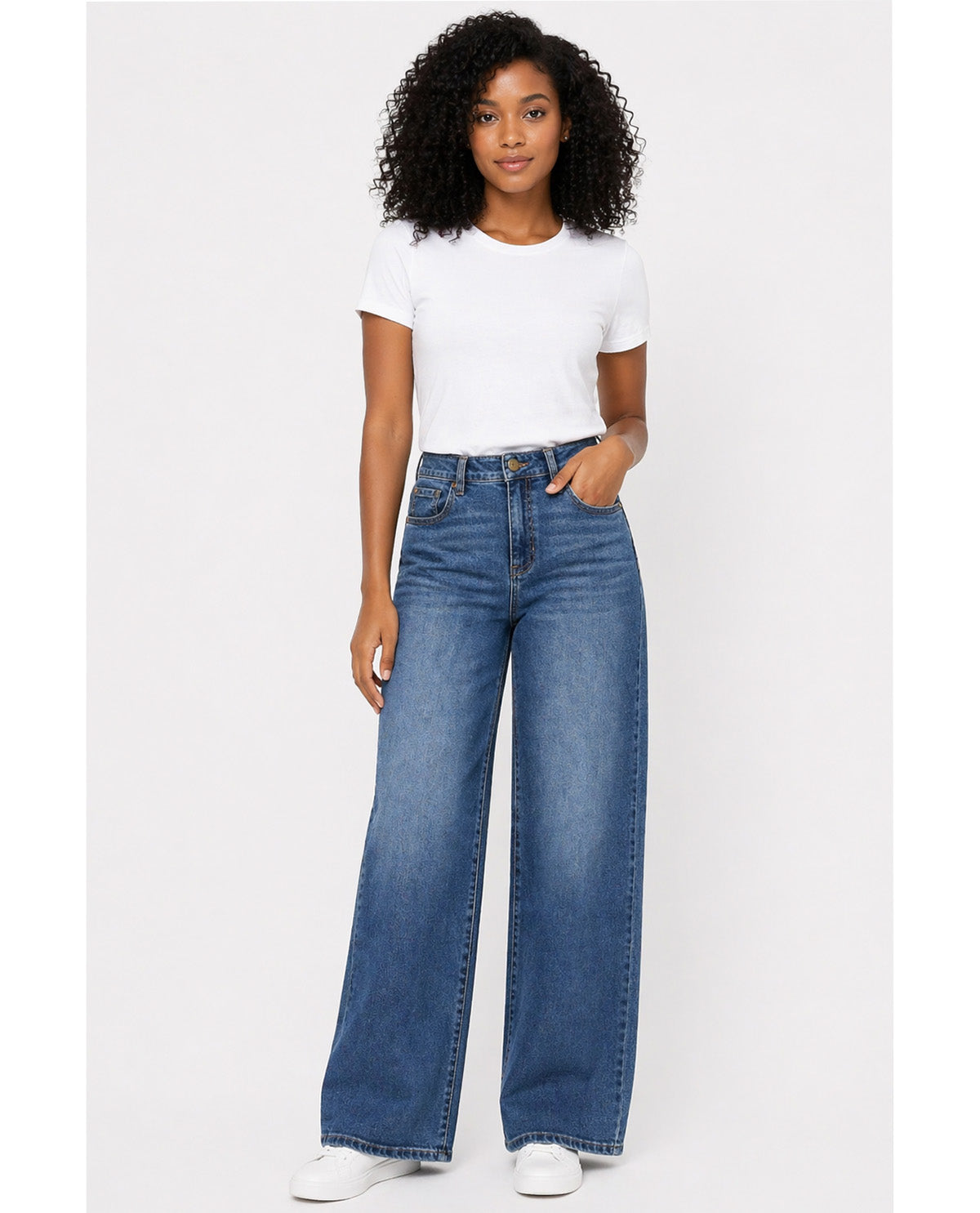 Woman wearing blue jeans and a white t-shirt on a white background