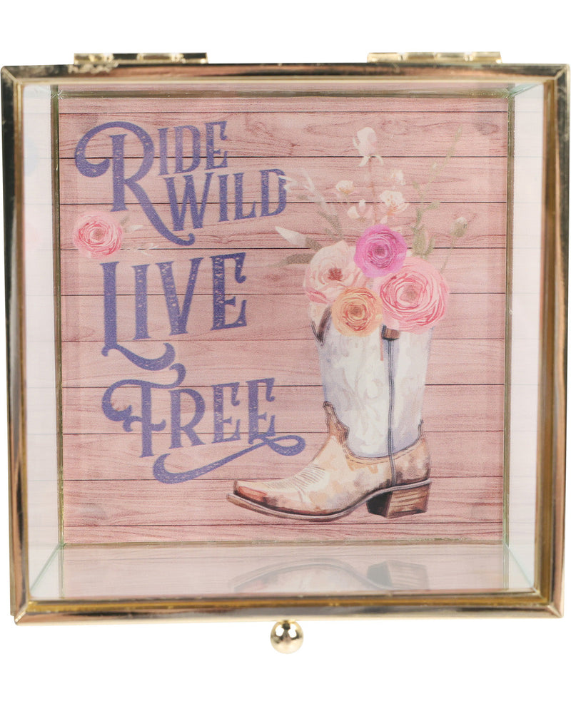 Decorative box with cowboy boot, flowers, and 'Ride Wild Live Free' text on a pink wooden background.