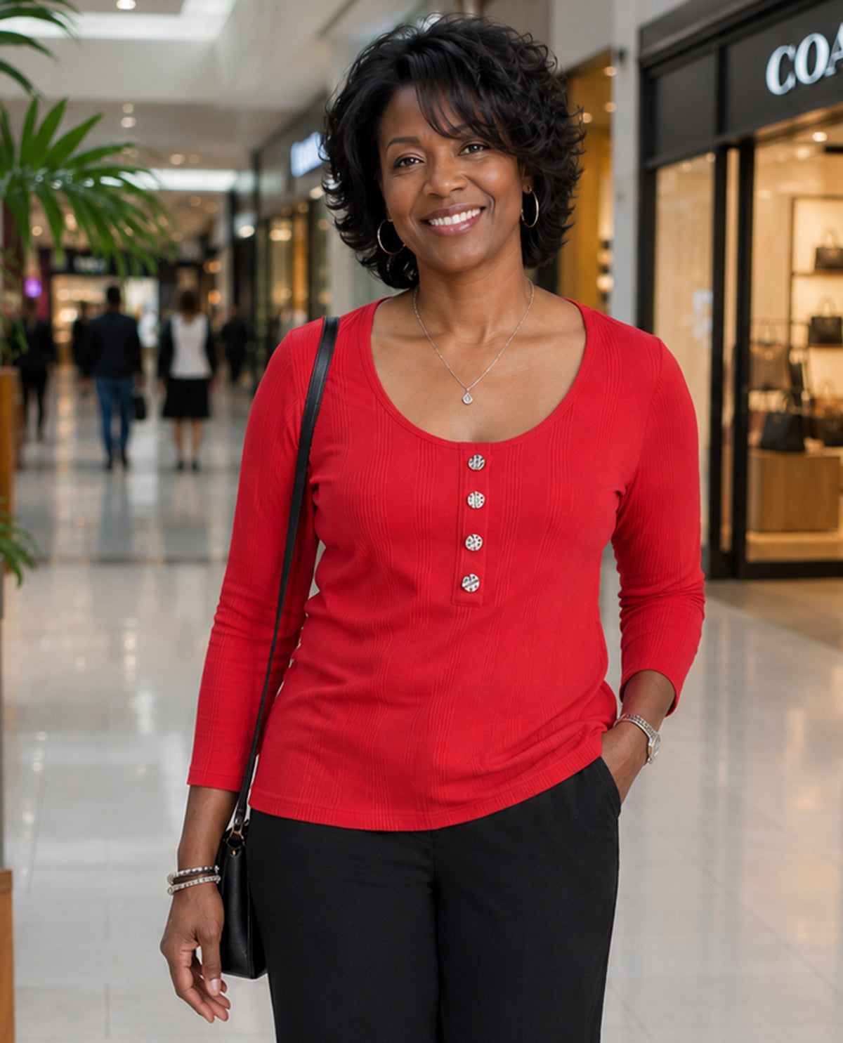 Woman in a red shirt standing in a shopping mall