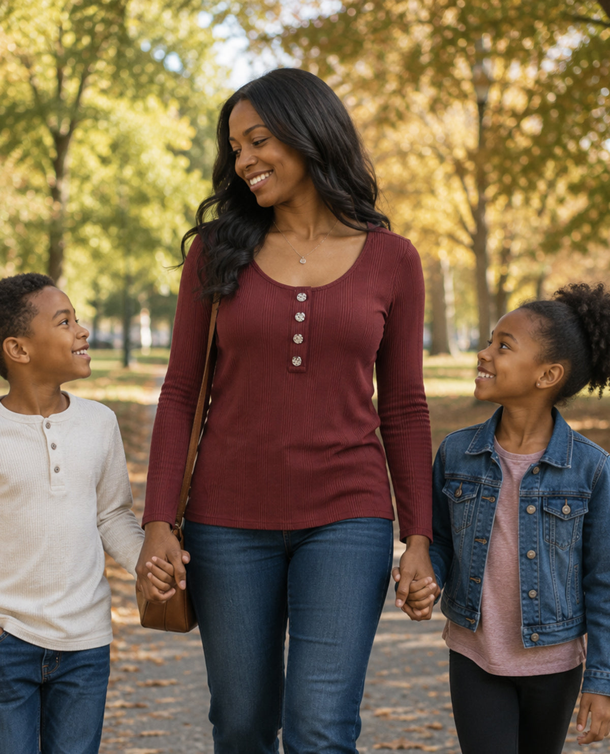 Woman walking with two children in a park during autumn