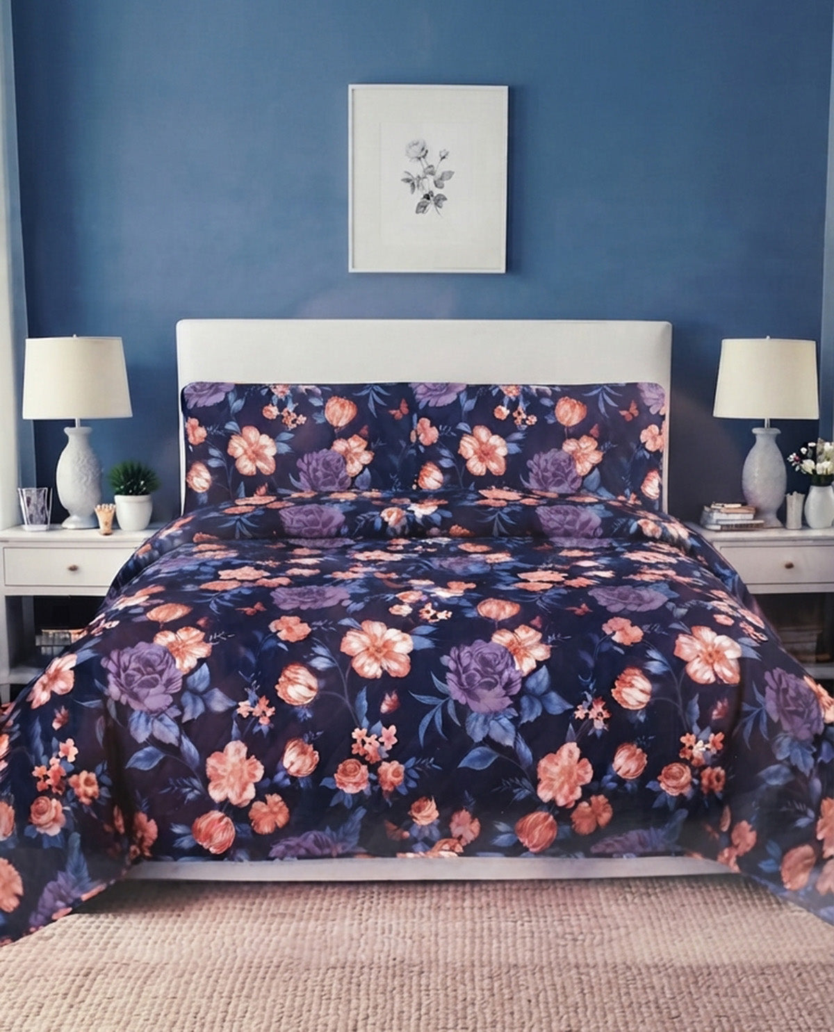 A floral comforter set with matching pillowcases in a bedroom setting. The comforter and pillows feature a dark navy blue background with large pink, purple, and orange flowers.