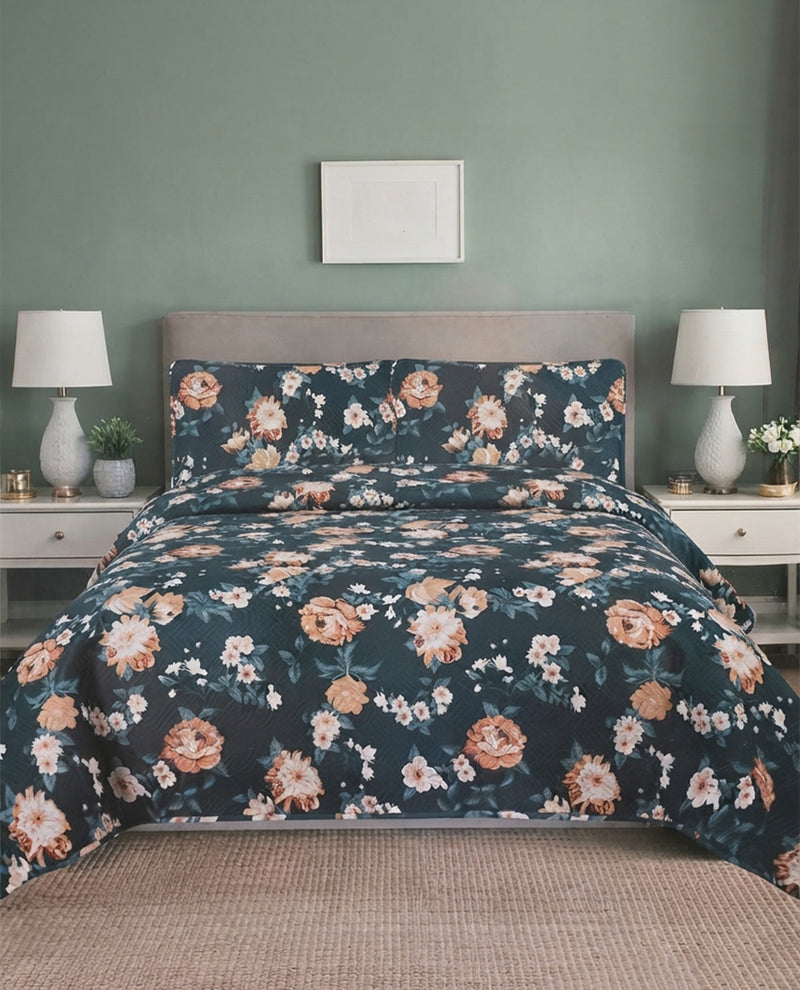 A floral bedding set featuring a dark navy blue duvet cover and matching pillowcases with a rose and white floral pattern, styled on a bed in a bedroom with a sage green wall, white nightstands, and lamps.