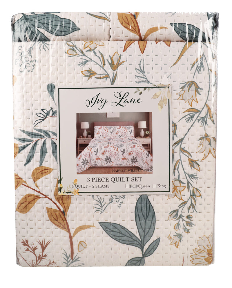 A packaged 3-piece quilt set by Ash Lane, featuring a floral and botanical pattern in muted green, mustard, and brown on a cream background. The product is wrapped in clear plastic and displays a central label showing the quilt styled on a bed.