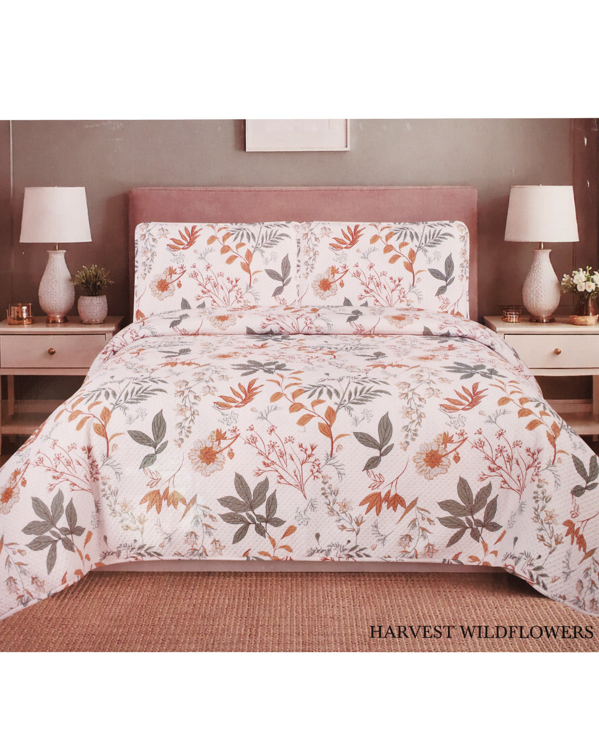 A floral comforter and matching pillow shams displayed on a bed in a styled bedroom setting. The pattern features orange, brown, and gray wildflower botanical motifs on a white background.