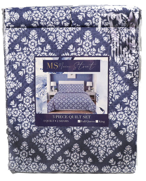 A packaged 3-piece quilt set by MSN America, featuring a navy blue and white damask pattern on the fabric, with a central product label showing a bed setup.