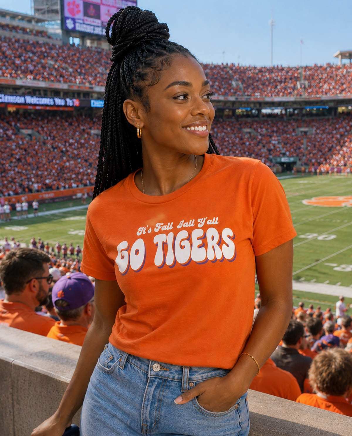 Woman wearing an orange 'Go Tigers' shirt at a sports event in a stadium.