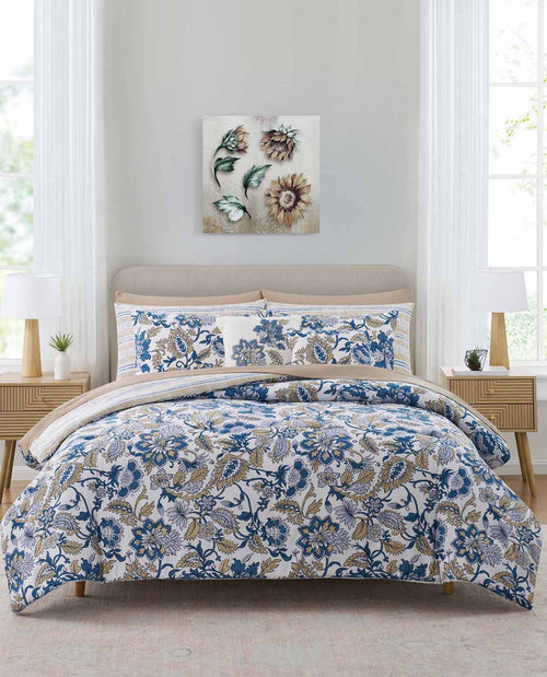 Floral bedding set on a bed in a bedroom with a painting on the wall.
