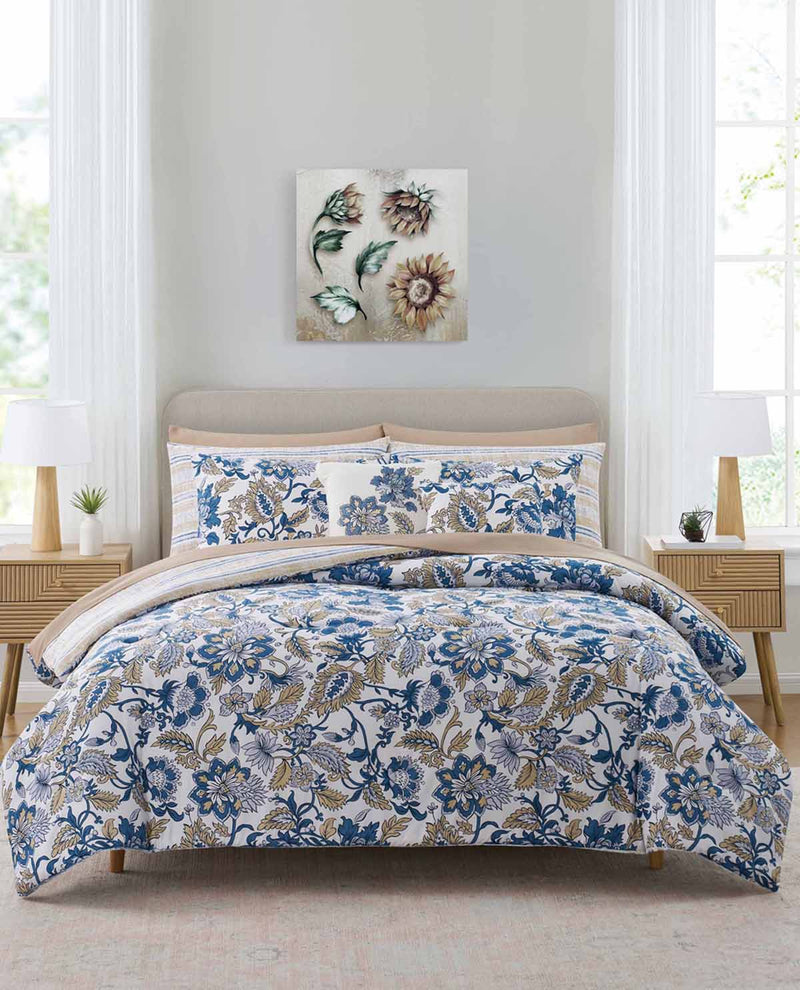 Floral bedding set on a bed in a bedroom with a painting on the wall.