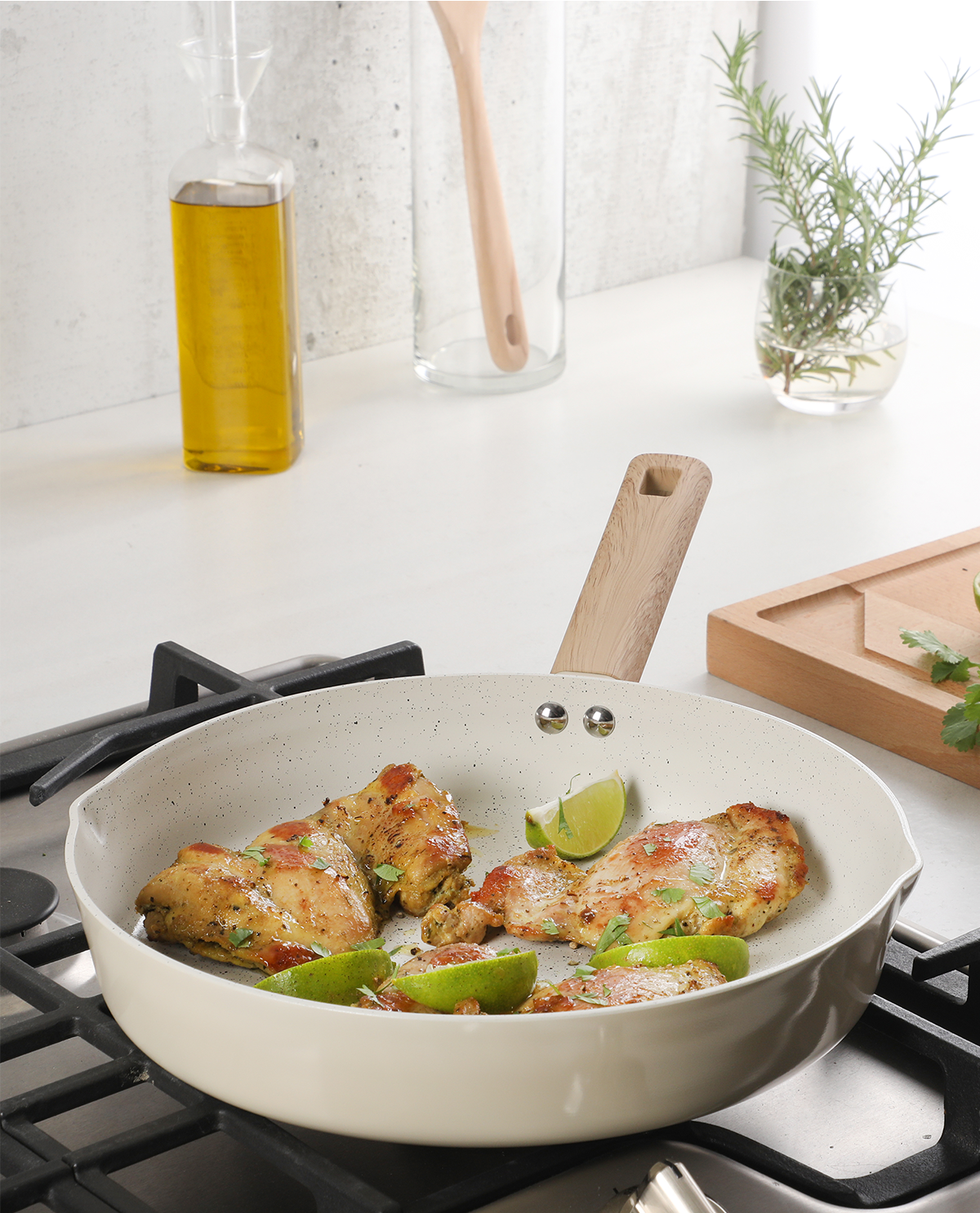 White ceramic cookware with chicken and lime on a stove
