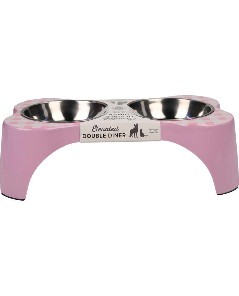 A pink elevated double pet feeder and water bowl set with stainless steel bowls, featuring a white label that reads 'Elevated DOUBLE DINER' on a plain white background.