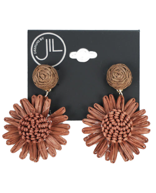 A pair of Discovery by JIL woven straw dangle earrings shaped like sunflowers, displayed on a black brand card against a white background.