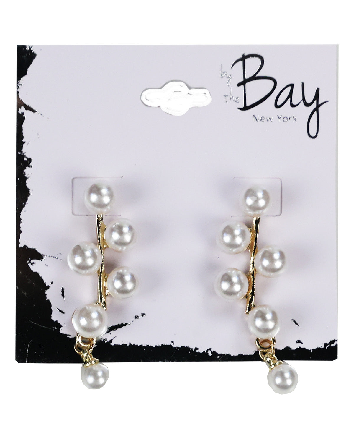 A pair of gold-tone dangle earrings with white faux pearls, displayed on a white and black 'by the Bay New York' retail card.