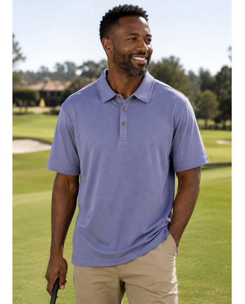 Man wearing a blue polo shirt on a golf course