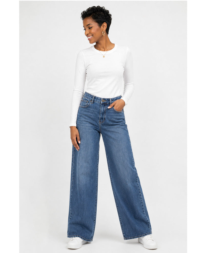 Woman wearing blue jeans and a white top on a white background