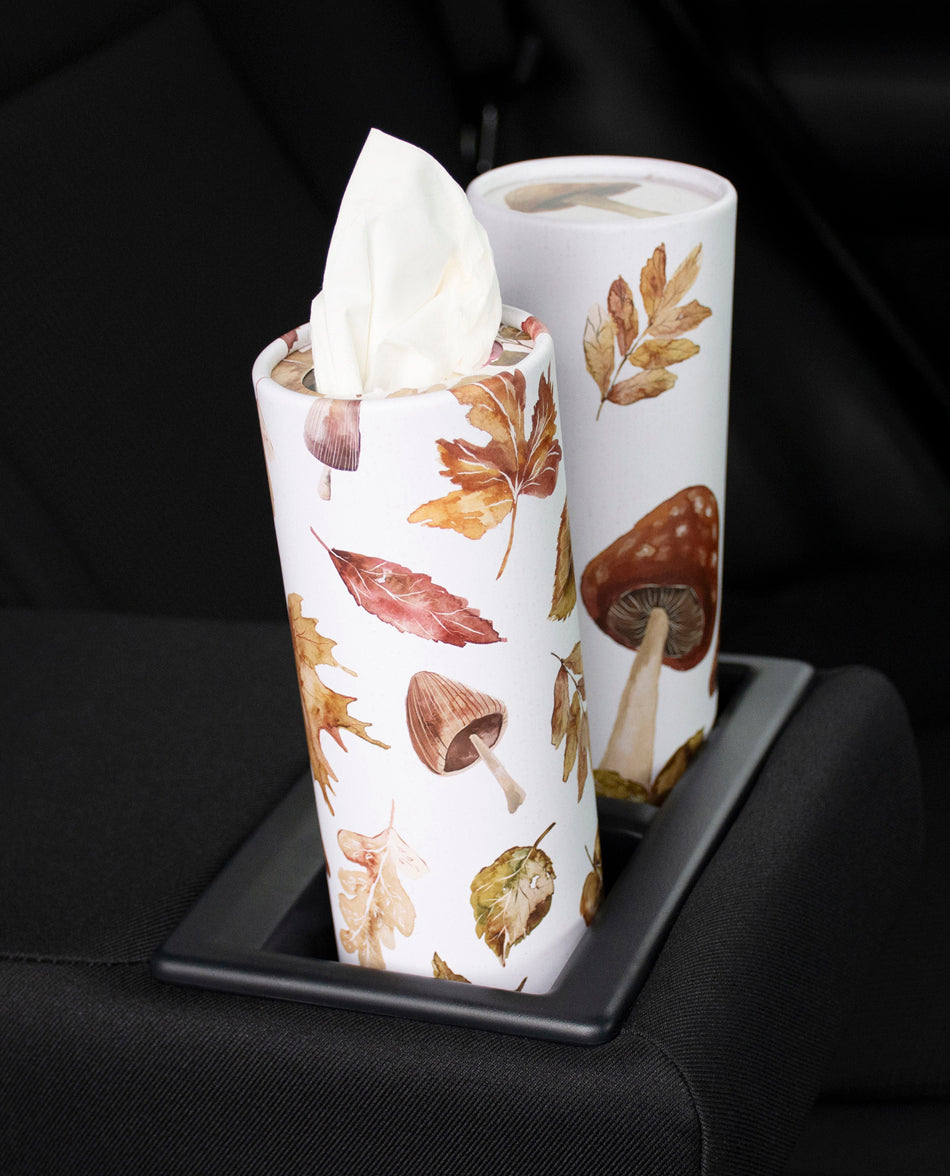 Two paper towel rolls with mushroom and leaf pattern on a black tray.