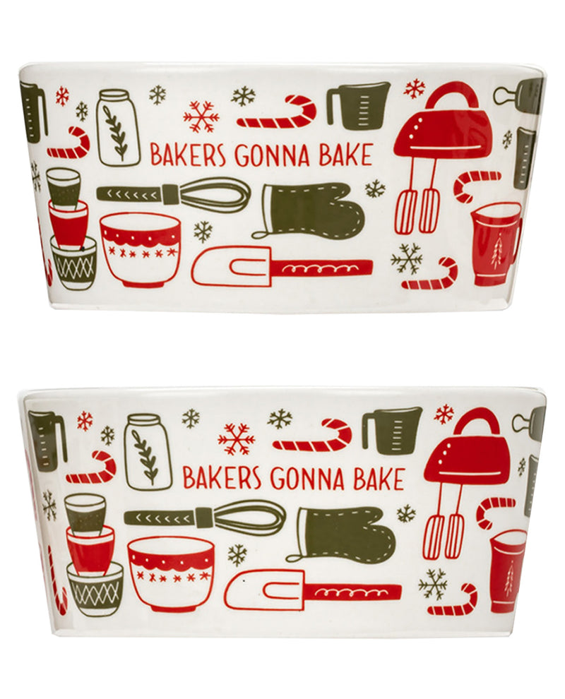 Two white rectangular baking pans with a festive holiday-themed print featuring red and green illustrations of measuring cups, mixing bowls, an oven, a hand mixer, candy canes, snowflakes, and the text 'BAKERS GONNA BAKE'.
