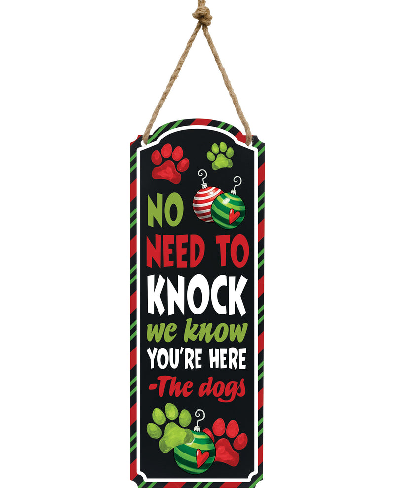 Decorative sign with paw prints and text 'No need to knock, we know you're here - The dogs' on a black background.