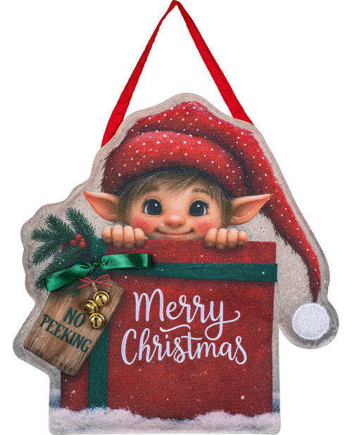 A Christmas hanging ornament shaped like a gift box with a peeking elf face, red Santa hat, green ribbon, snow-dusted edges, and a wooden tag that reads 'NO PEEKING Merry Christmas' on a white background.