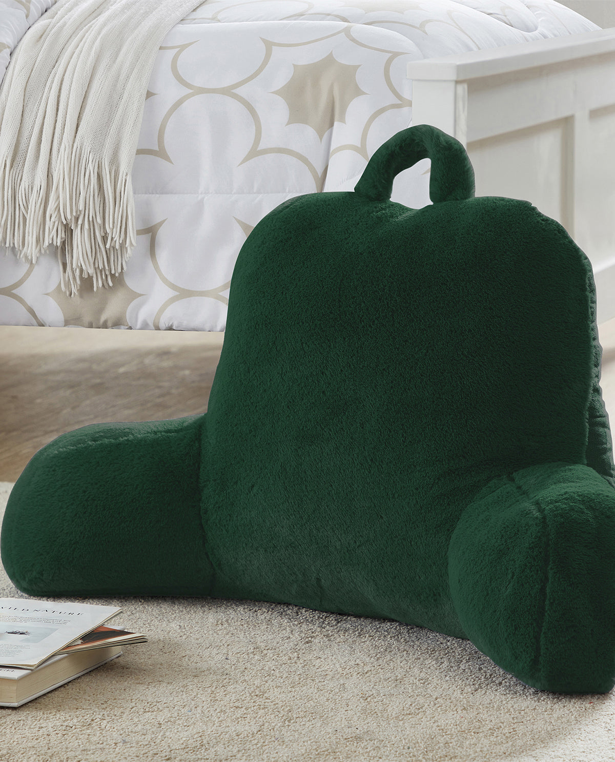 Green backrest pillow on a bed with a patterned headboard in the background