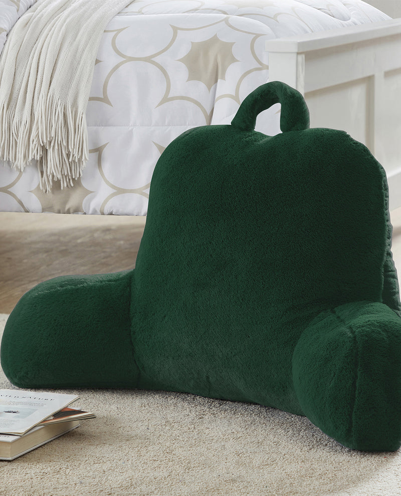 Green backrest pillow on a bed with a patterned headboard in the background