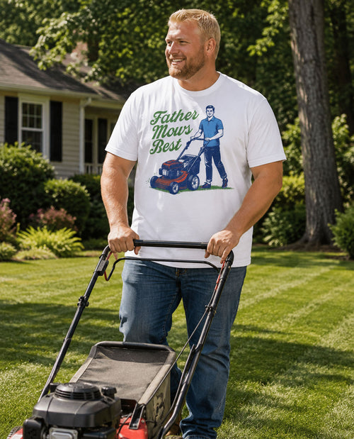 Man mowing a lawn wearing a t-shirt with a graphic design.