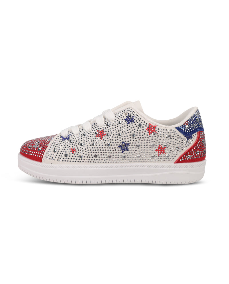 A low-top white sneaker embellished with sparkling rhinestones in red, white, and blue star patterns, featuring a red and blue rhinestone-embellished toe cap and heel tab, set against a plain white background.