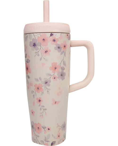 Floral-patterned tumbler with a pink lid and handle on a white background