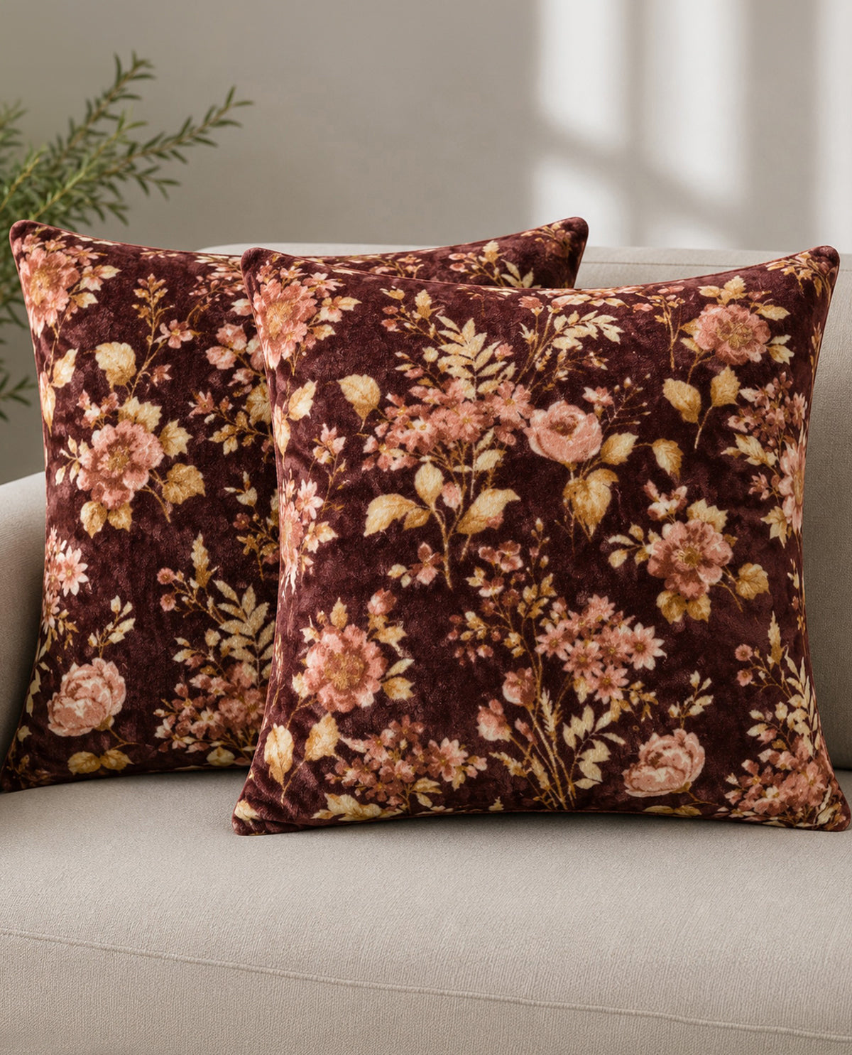 Floral patterned pillows on a couch with a neutral background