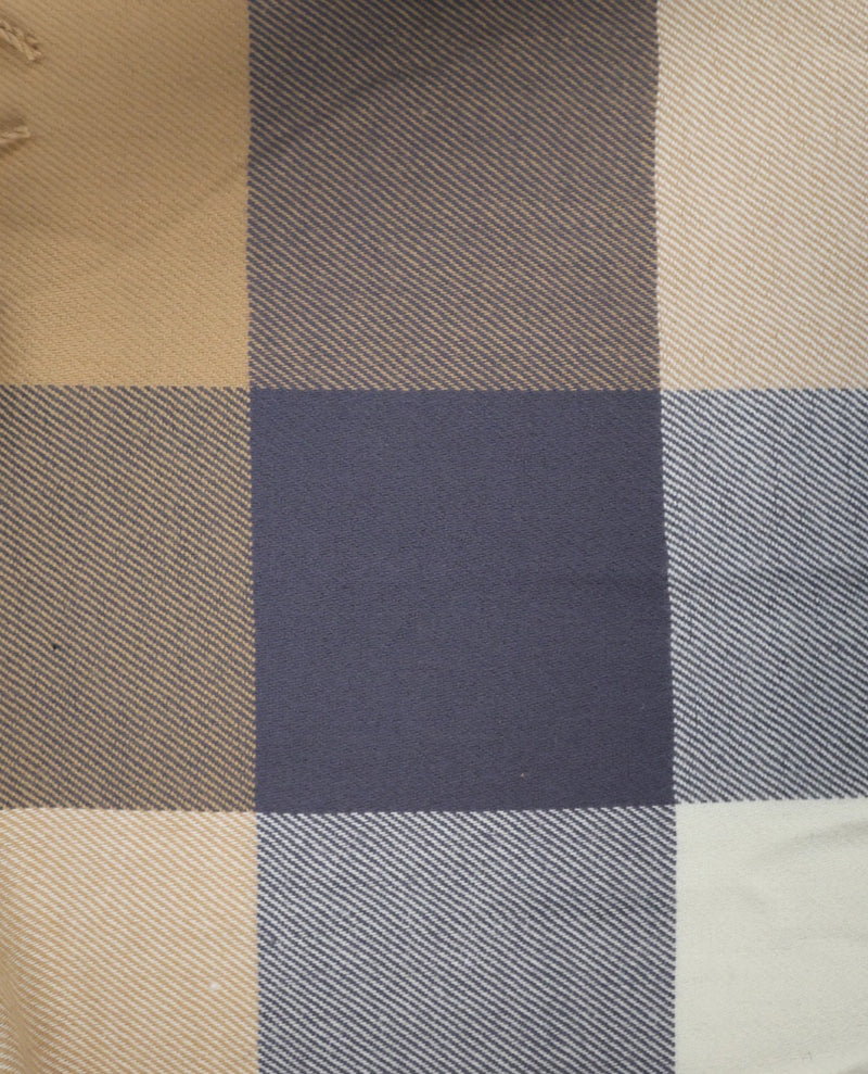 A close-up of a plaid fabric pattern with intersecting blocks of beige, navy blue, gray, and off-white, showing a woven texture.