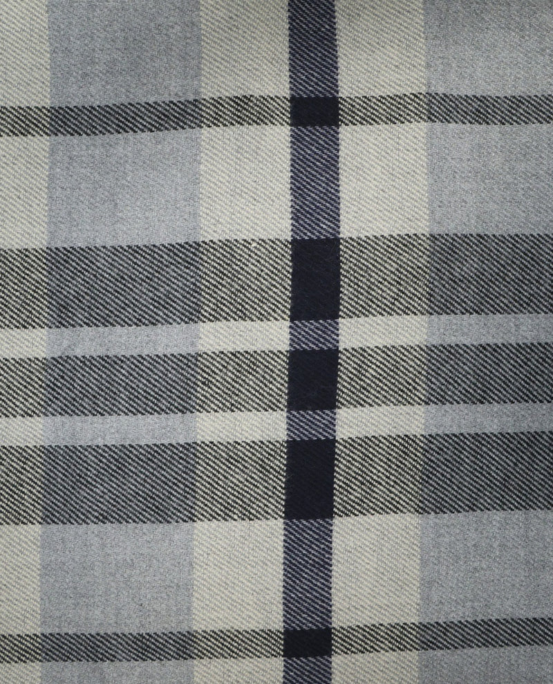 A close-up of a plaid fabric pattern with intersecting horizontal and vertical stripes in gray, off-white, and dark navy blue.