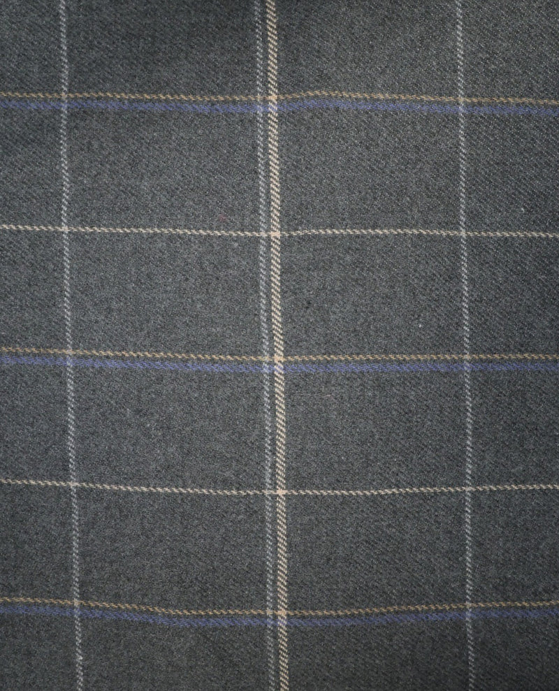 A close-up of dark gray plaid fabric with a windowpane pattern in beige and blue.
