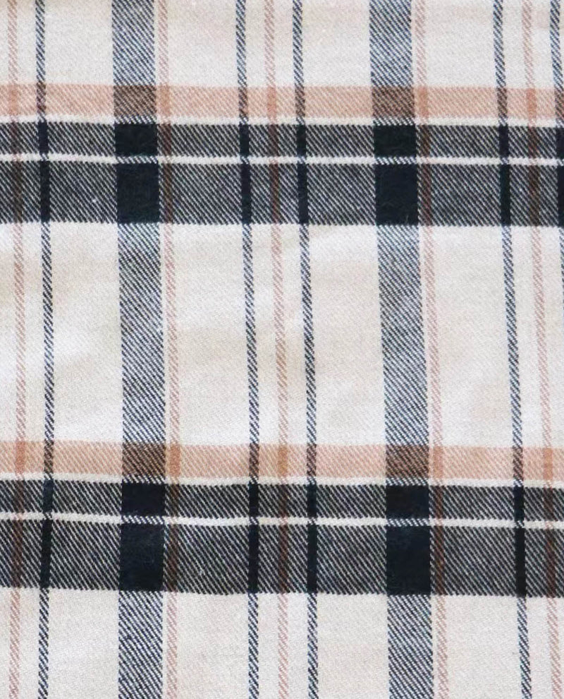 Close-up of a plaid fabric with black, white, and beige colors.