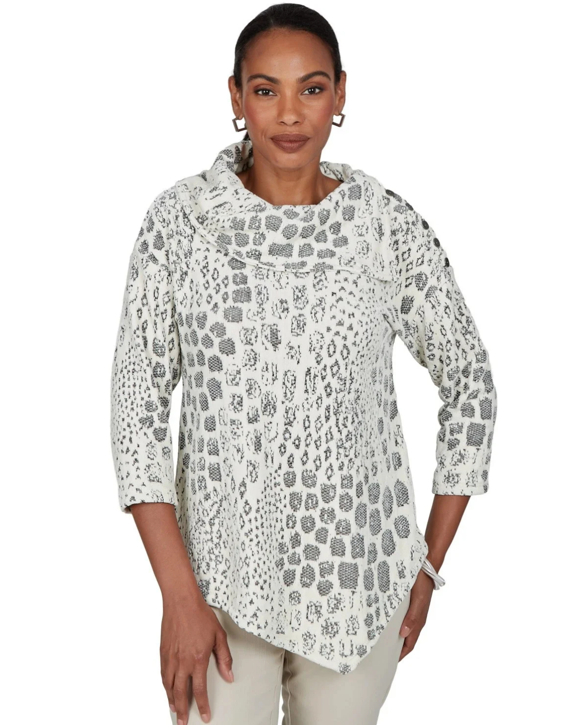A woman modeling a white three-quarter sleeve tunic top with a gray leopard print pattern, paired with light beige pants, against a plain white background.